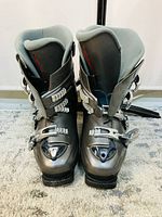 Front view of gray ski boots showing padded interior and several buckles.