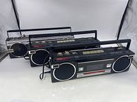Front and angled view showing all three boomboxes with black bodies and silver speaker covers, from smaller to larger, Panasonic brands visible on two, Sony on one.