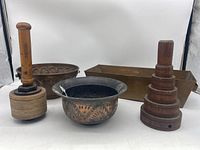 Overview photo of all items: two copper bowls (one hammered, one fluted with handles), rectangular copper potting pan, wooden tamper, wooden round molds stack