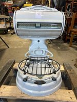 Front view of the white enameled antique computing scale with round metal weighing platform and visible scale window.