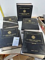 Photo showing 5 large black binders labeled 'U.S. First Day Covers & Special Covers' from the Postal Commemorative Society.