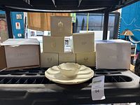 Several Lenox boxes and a beige-colored dish on display showing the lot contents