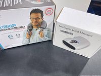 Boxes of the HoMedics Pro Therapy Vibration Neck Massager and the Intelligent Hand Massager.