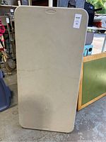 Top view of the beige Samsonite folding table surface showing texture and brand logo.