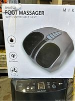 Box of shiatsu foot massager showing product image and key features like heat, air pressure, and kneading.