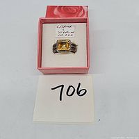Top view of the sterling silver ring with citrine gemstone inside a pink box with a note indicating citrine and sterling silver, 10.2 grams, lot number 706