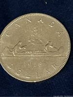 Full obverse of 1978 Canadian dollar coin with Voyageur design showing two paddlers in a canoe and date 1978 under.