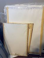 Three wooden canvas frames showing front views of stretched white canvas surfaces, sizes 16 x 22 inches (two) and 24 x 32 inches (one).