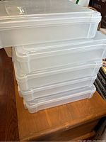 Stack of five clear plastic scrapbook totes showing lid and stacking design