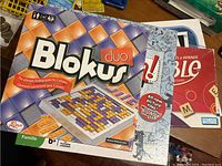Photo showing the boxed games Blokus Duo, Pictureka!, Scrabble, and Sorry stacked together.