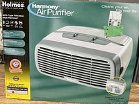 Photo showing the boxed Holmes Harmony Air Purifier with product image, features including HEPA-type filtration, advanced filter, and certification for rooms up to 11 m².