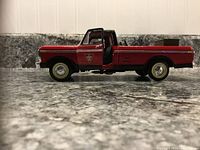 Side view of red and black 1979 Ford pickup die-cast model with open driver door, Canadian Tire logo on door visible