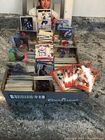 Box containing stacked hockey cards with some displayed vertically in plastic holders showing player images and rookie cards.
