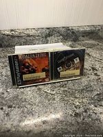 Photo of two PlayStation 1 games, Martian Gothic and Darkstone, displayed side by side on a granite countertop.