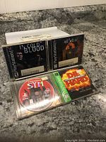 Photo showing four PlayStation 1 game cases on a countertop: 'Cold Blood,' 'Hexen,' 'Cardinal Syn,' and 'Die Hard Trilogy'