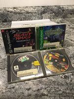 Photo of 4 PlayStation 1 games with cases and discs visible on countertop.