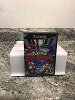 Pokémon Colosseum GameCube game case with cover art showing legendary Pokémon on front.