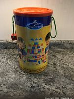 Closed tub of Imaginarium 150 piece wooden blocks set showing label with children playing with blocks.