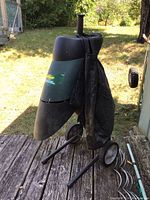 Photo showing a Yardworks electric corded yard shredder outdoors with black fabric collection bag attached and wheels for mobility.