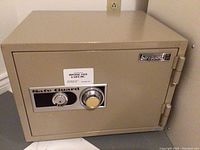 Front view of the beige SafeGuard safe showing combination dial and key lock.