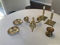 Wide shot of all brass candle holders placed on a white cloth
