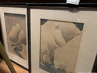 Two framed artworks resembling Japanese woodblock prints with mountain and water scenes, showing the relative sizes and framing.