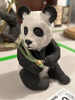 Front view of Boehm porcelain panda holding bamboo, showing face and arms.