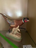 Front and side view showing entire pheasant sculpture on a base.
