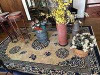 Full view of blue and white patterned rug with decorative border and miscellaneous items on top for scale.