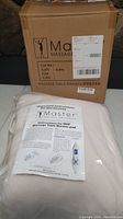 Box labeled Master Massage with the fleece warming pad packed inside along with paper instructions visible on top.