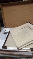 Kit panels packed inside cardboard box with foam padding and plastic bags containing screws and hardware.