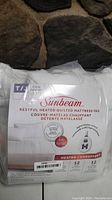 Packaged Sunbeam Restful Heated Quilted Mattress Pad in twin size, showing brand and product details.