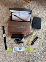 Photo showing the entire lot with Cross fountain pen in box, Timex watch, Prestige card holder, folding knife, and multi-tools.