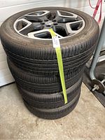 Stack of four Subaru OEM alloy wheels with mounted tires photographed from side