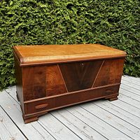Full view of the antique wooden storage chest showing the front and top with cedar wood finish and drawer at the bottom