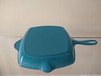 Bottom view of the vintage Le Creuset skillet showing the flat base and baby blue enamel finish.
