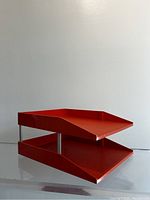 Full side-angle view of the two-tier orange letter paper sorter made of plastic with metal rods between tiers.