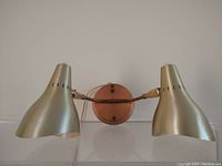 Front view of the vintage mid-century modern wall mount lamp showing both heads and round wooden backplate.