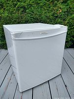 Exterior view of the white Danby mini fridge showing slight wear.