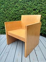 Front side view of the oak cube chair showing its squared geometric design and flat armrests.