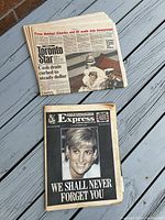 Photo of three newspapers stacked featuring front page coverage of Princess Diana and Royal events from 1980s and 1990s.