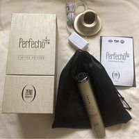 Complete set including Perfection Zero Gravity infrared heat facial repair device, charging base, power adapter, storage pouch, instruction manual, and box.