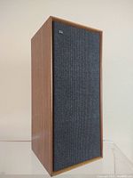 Front view of vintage Celestion Ditton 15 speaker showing teak wood grain and black fabric grille with brand emblem.