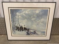 Framed limited edition print of a snowy winter scene by RGauthier featuring two children playing near snow-covered houses under a cloudy sky.