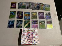 Full spread of 20 Japanese Pokémon cards arranged in rows with the Pokémon 151 box in front