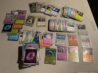 Overview of assorted Pokemon trading cards including energy and character cards arranged on table