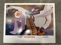 Color photo of vintage Disney lobby card showing scenes and characters from The Rescuers movie.