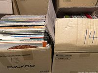 One box of vinyl records showing a variety of colorful sleeves stored vertically