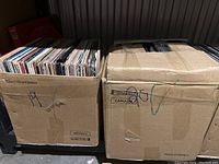 Two cardboard boxes filled with assorted vinyl records, marked 19 and 20.