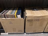 Two cardboard boxes labeled 21 and 22, each filled with vinyl records.